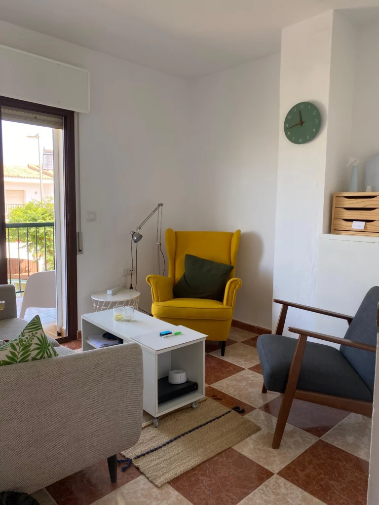 Bright therapy room at Unison Health with a yellow armchair and a balcony door